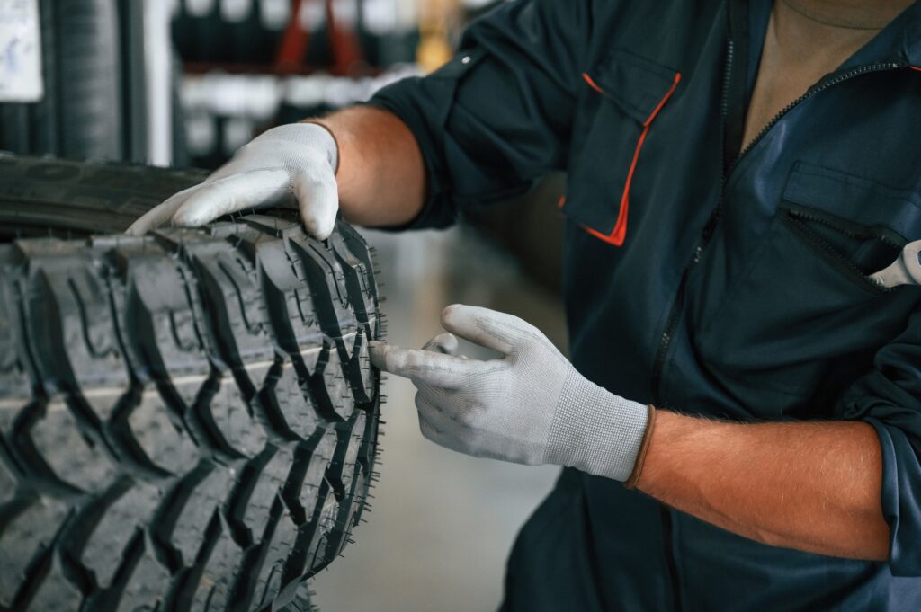 Conception of maintenance. Man is in the tire fitting car service