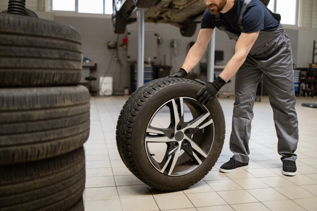 Mechanic changing car tire in a professional auto repair shop